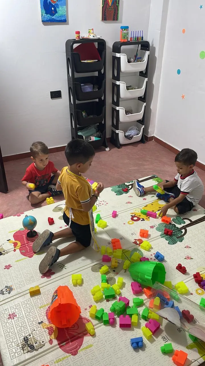 Niñas y niños jugando con bloques de colores en la ludoteca