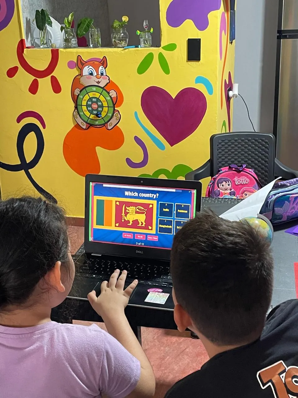 Niñas y niños frente a un computador en una actividad del club de inglés