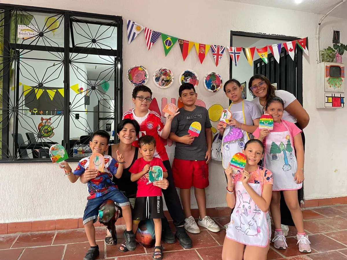 Grupo de niñas, niños y maestras celebrando en las vacaciones recreativas